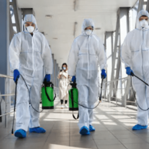 Three people in suits disinfecting in a building
